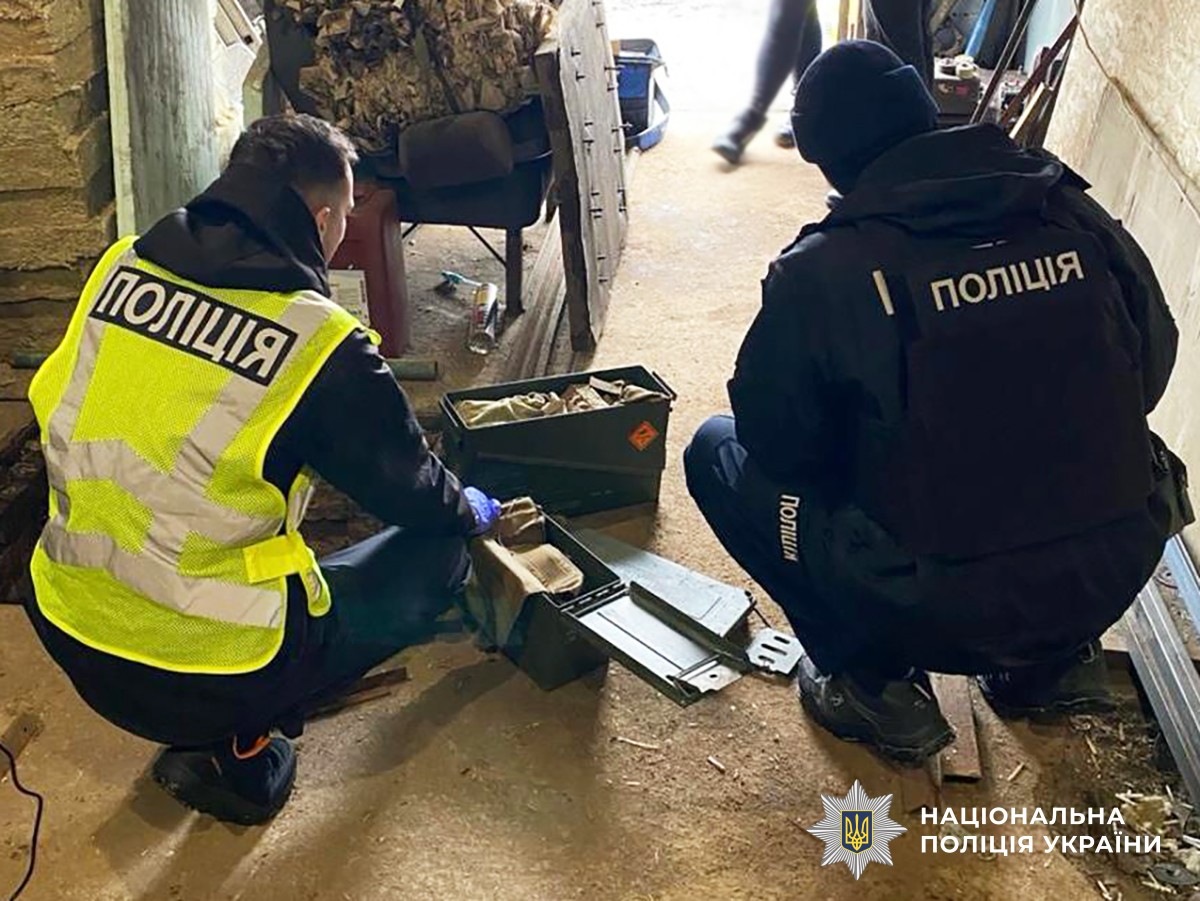 Двоє поліцейських оглядають виявлені боєприпаси