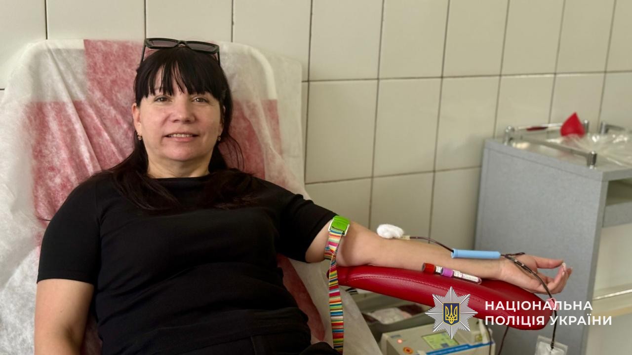 Поліцейська сидить у медичному кріслі та здає кров
