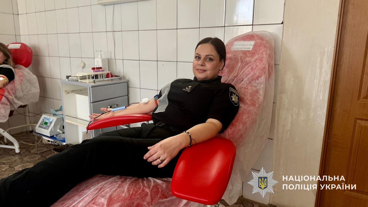 Поліцейська сидить у медичному кріслі та здає кров