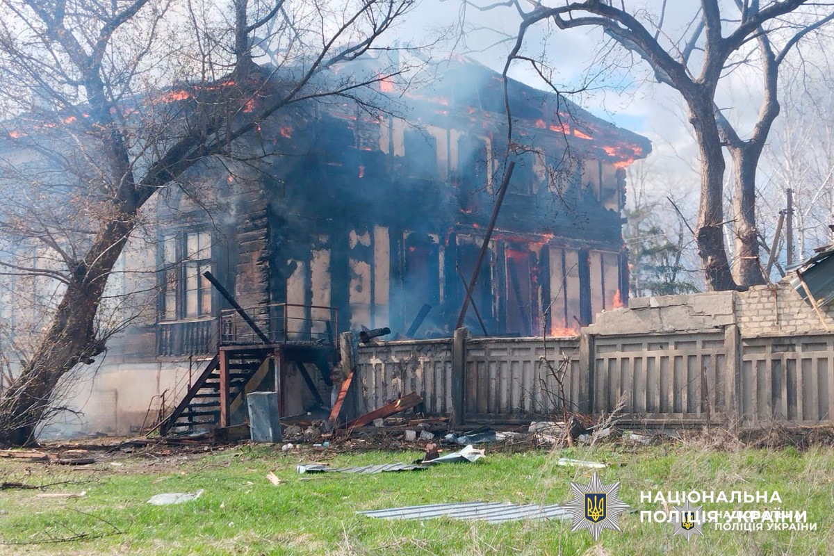 Двоповерхова будівля у вогні, дим здіймається над дахом.