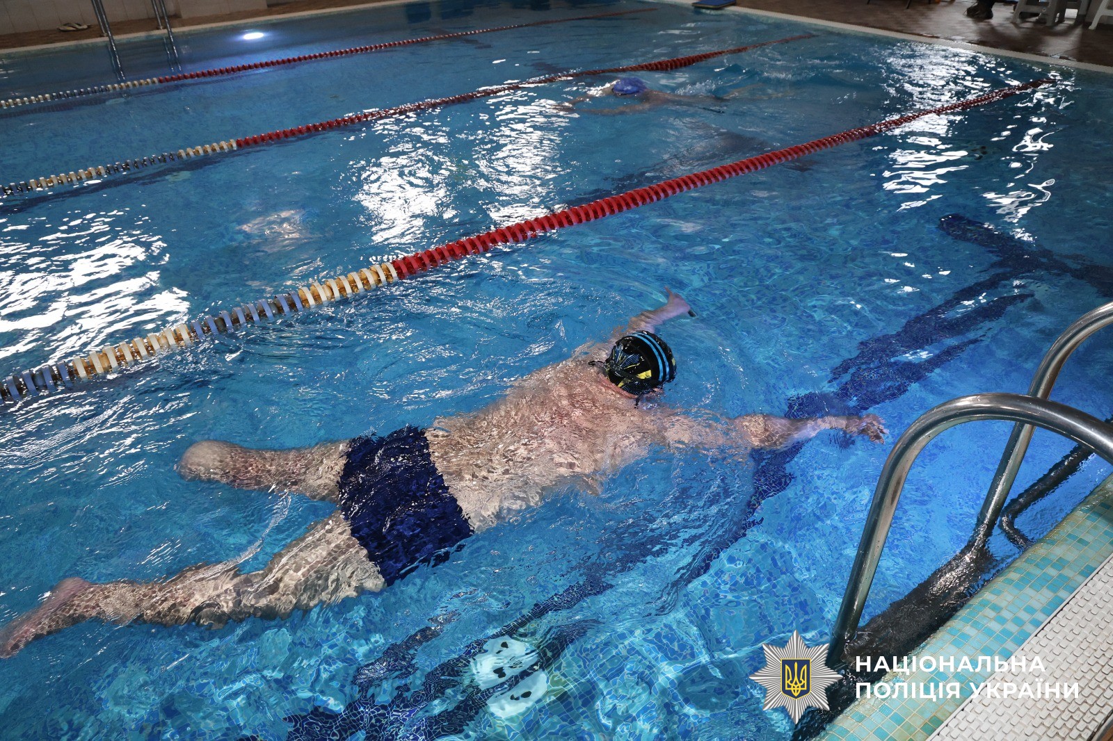 Чоловік займається у басейні