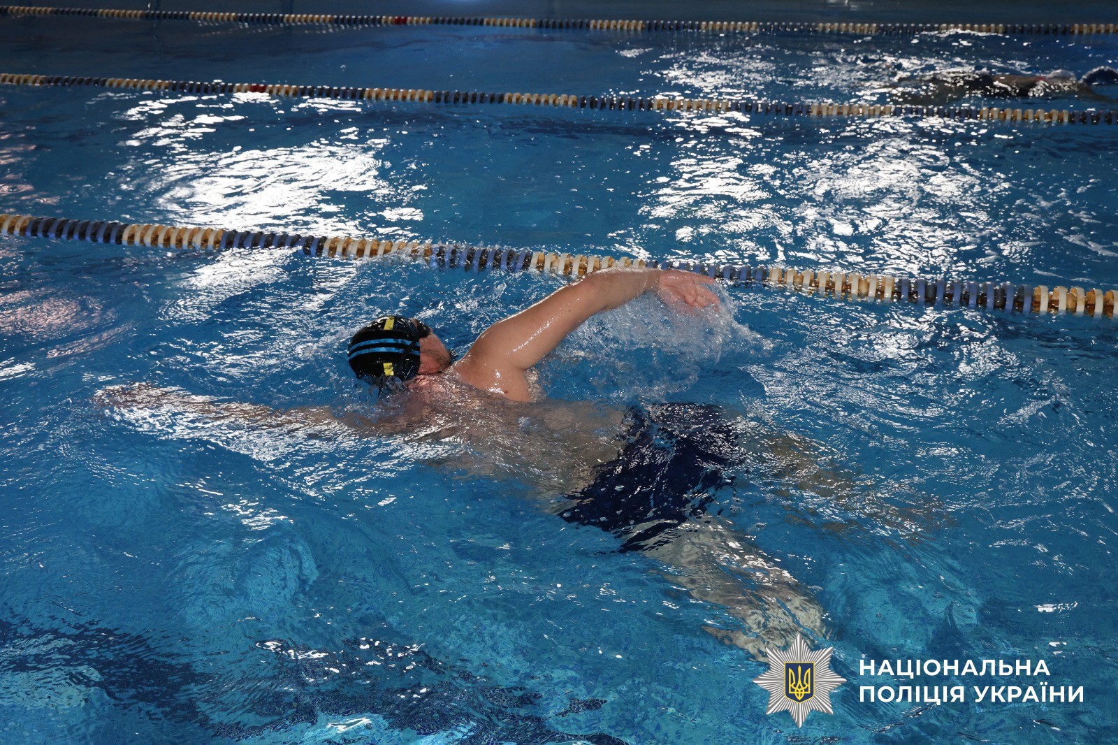 Чоловік займається у басейні