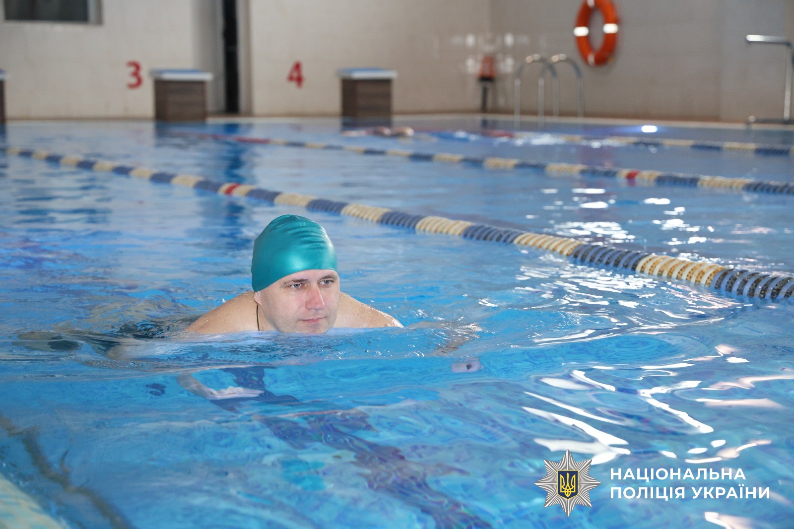 Чоловік займається у басейні