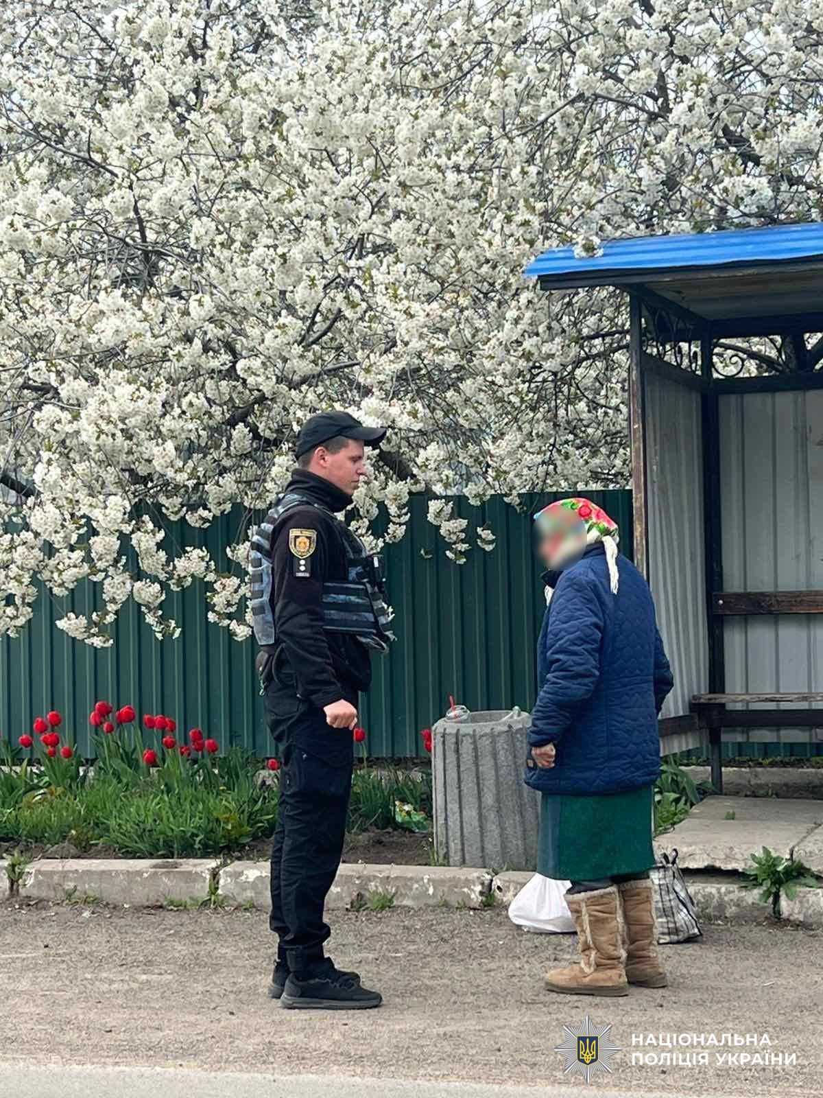 Поліцейський допомогає літній жінці