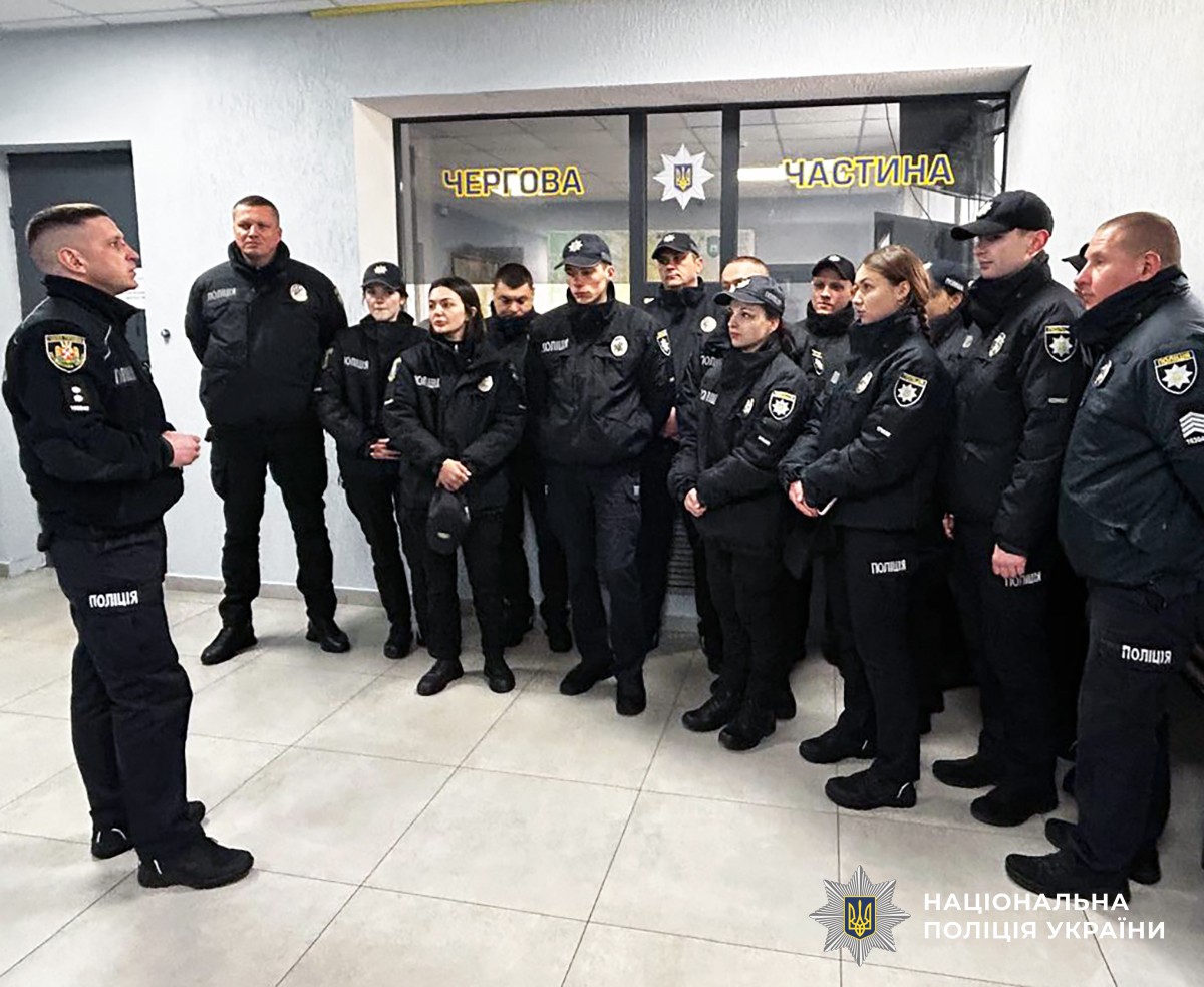 Група слухачів академії поліції стоять в холі райуправління та слухають офіцера