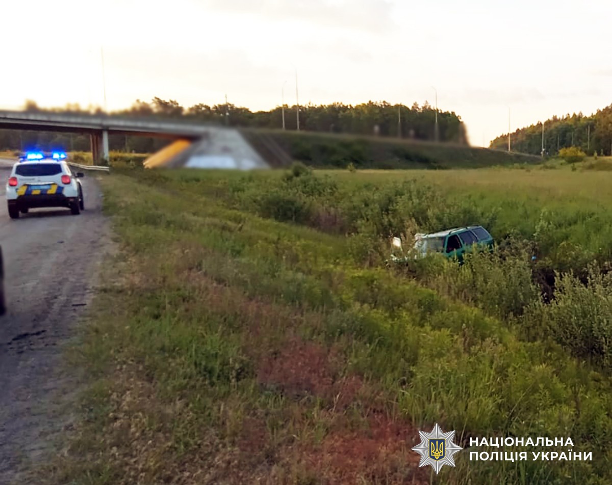 Автомобіль поліції на дорозі, зелений легковик в кюветі