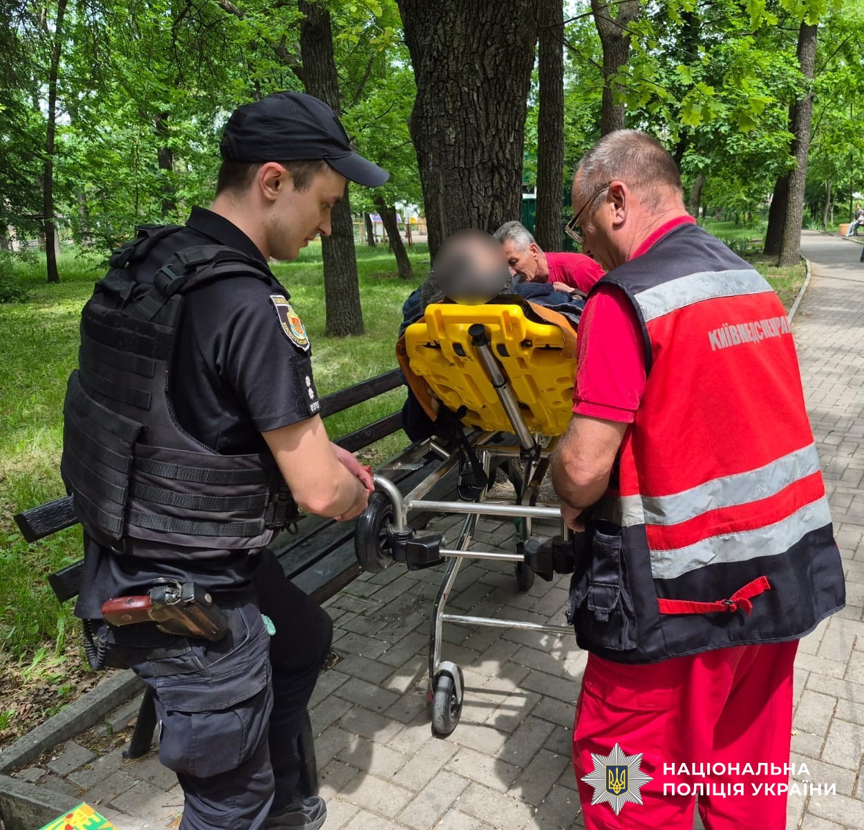 Поліцейський та медик допомагають чоловікові