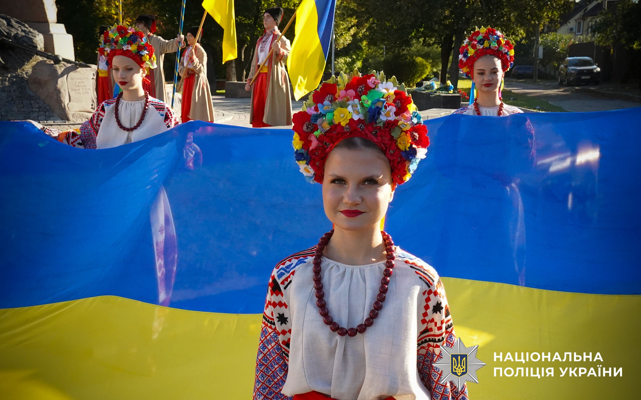 Дівчина в українському вбранні на фоні прапора