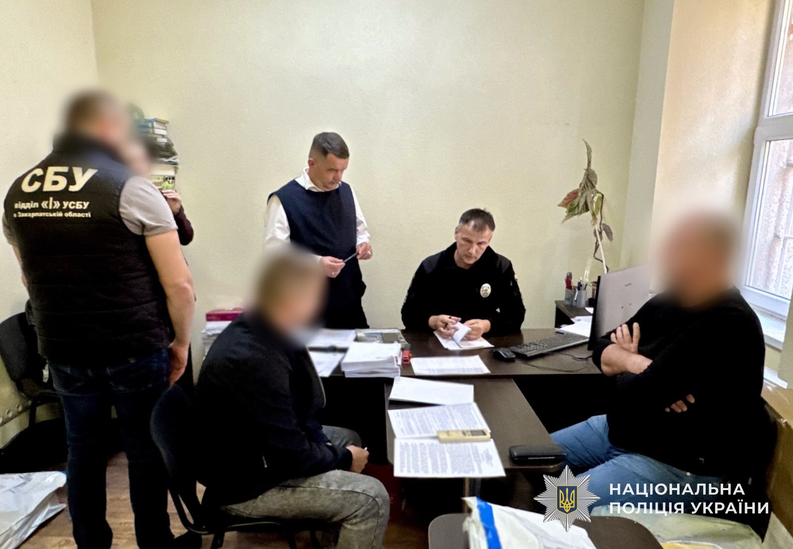 Слідчий оголошує підозри двом фігурантам у справі про продаж електроенергії зі збитками державі понад 18,1 млн грн. Також на фото присутні прокурор та співробітник СБУ